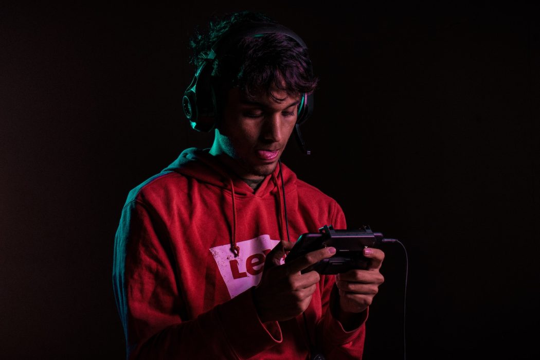 Guy playing on mobile with headset on